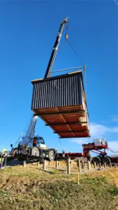 crane lifting rse accommodation cabin onto piles nz