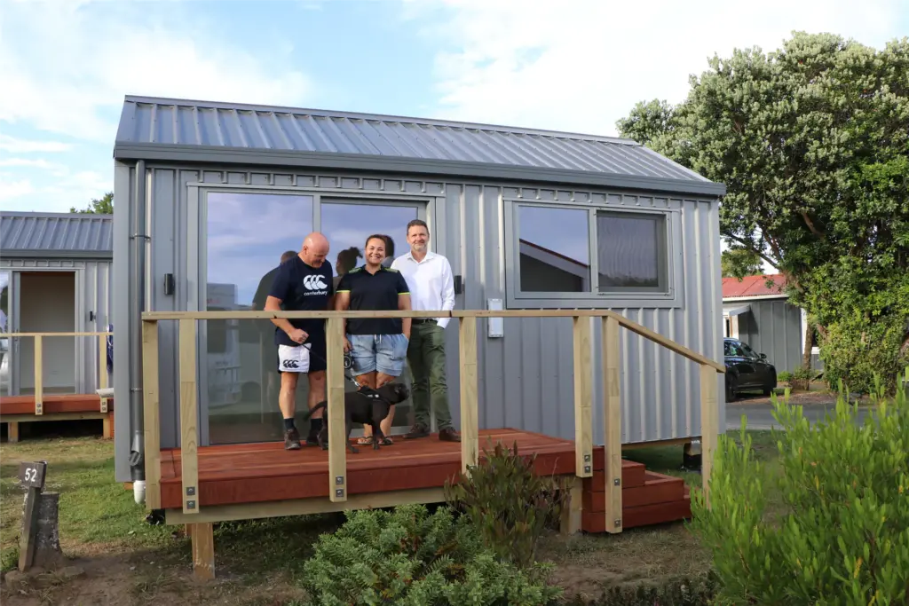 Happy customers on the deck of a new Cosy Cabins holiday park cabin