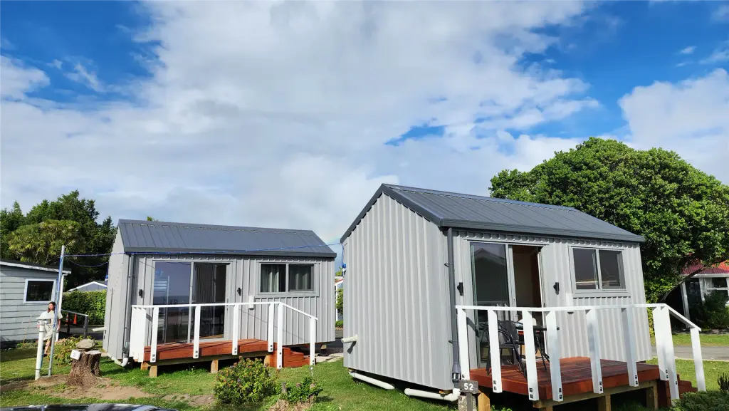 Two custom holiday park cabins with grey cladding and decks at Collingwood Holiday Park