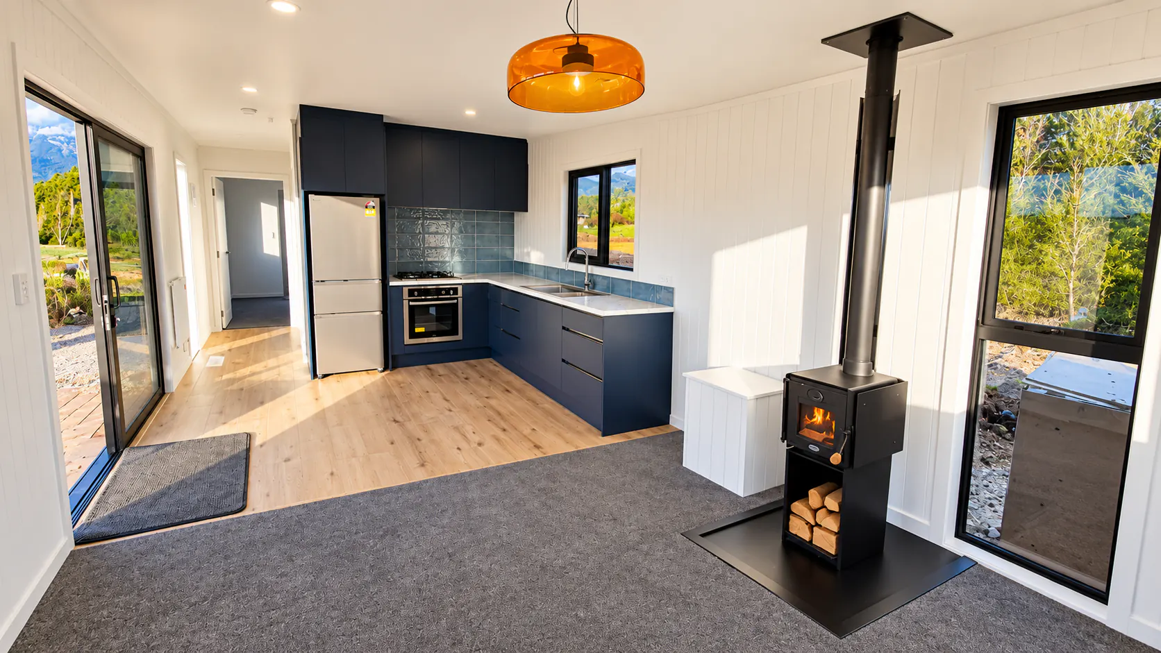 tiny home kitchen wood stove orange pendant takaka hill nz