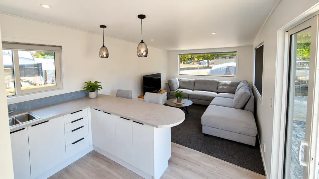 Open-plan kitchen, dining and lounge area inside a custom tiny home